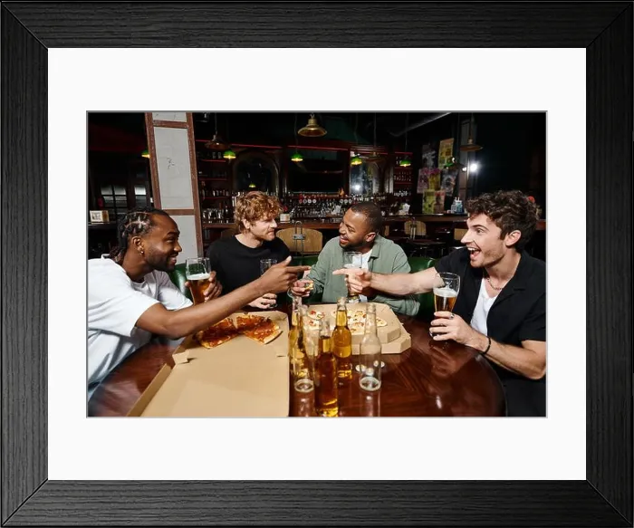 Framed Print : happy multiethnic friends joking, gesturing and chatting over pizza with beer, men on bachelor party Framed Print : happy multiethnic friends joking, gesturing and chatting over pizza with beer, men on bachelor party