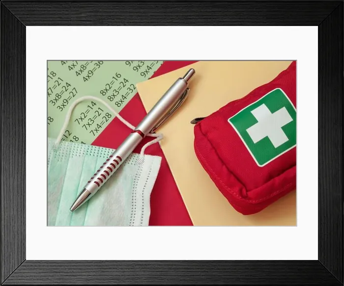 Framed Print : Pen, medical mask and first aid kit on a school notebook
