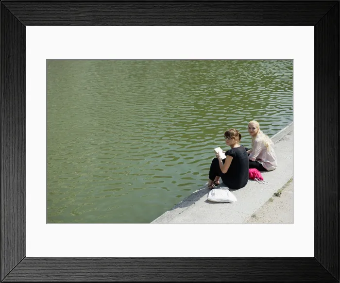 Framed Print : Young women sitting beside lake together Framed Print : Young women sitting beside lake together