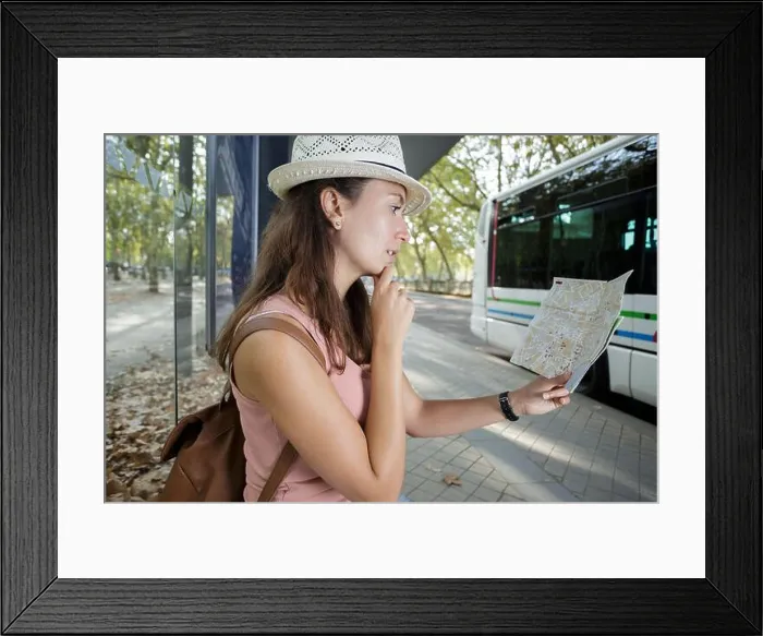 Framed Print : woman reading a map while waiting at bus stop Framed Print : woman reading a map while waiting at bus stop