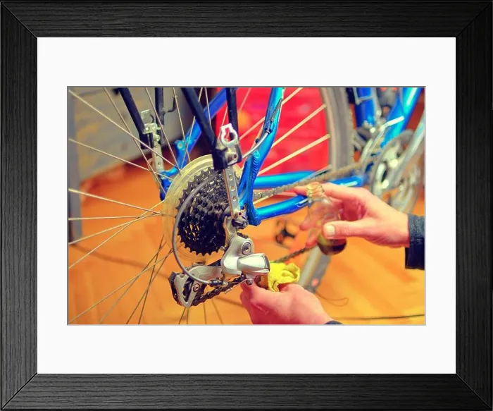 Framed Print : Closeup of male hands cleaning and oiling a bicycle chain and gear with oil Framed Print : Closeup of male hands cleaning and oiling a bicycle chain and gear with oil