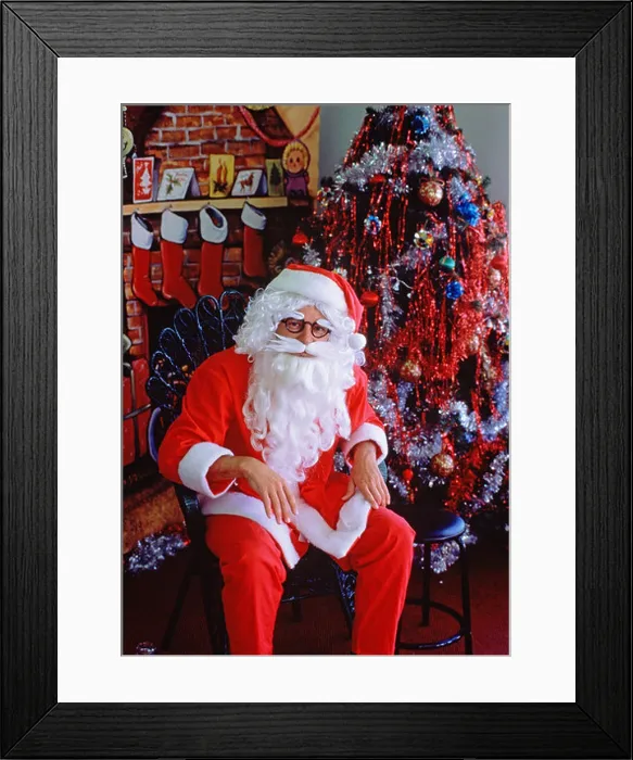 Framed Print : Santa Claus (Father Christmas) sitting in store setting by Christmas tree