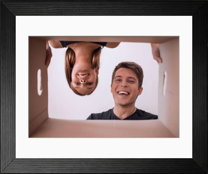 Framed Print : close up. happy couple looking into a cardboard box Framed Print : close up. happy couple looking into a cardboard box