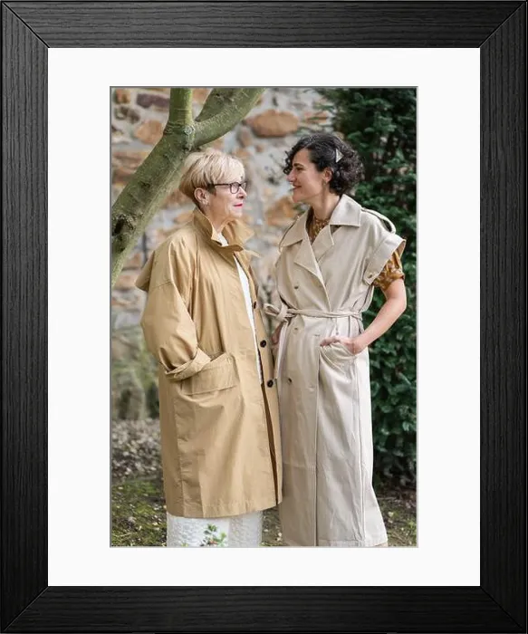 Framed Print : Two fashion women in stylish beige trench coats share a joyful moment outdoors