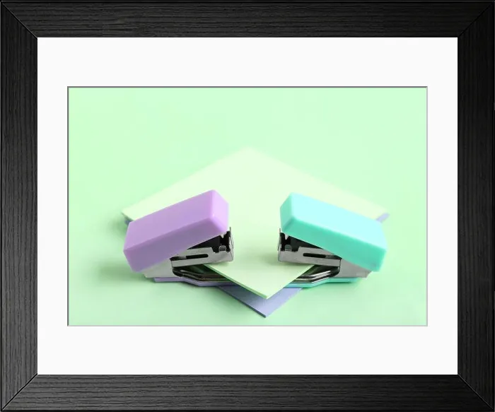 Framed Print : Different small staplers with sticky notes on green background Framed Print : Different small staplers with sticky notes on green background