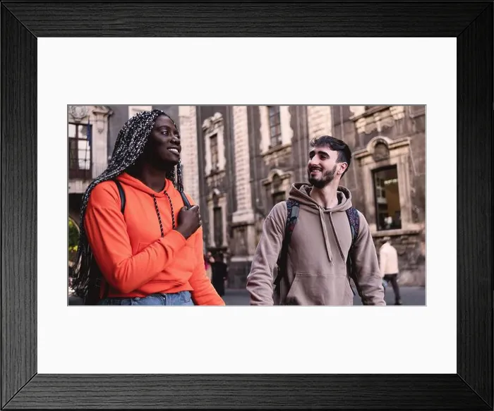 Framed Print : Multiracial couple of young tourists walking in the historic city center Framed Print : Multiracial couple of young tourists walking in the historic city center