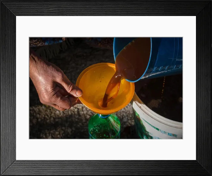 Framed Print : Old woman's hands pouring juice from pan in bottle via funnel Framed Print : Old woman's hands pouring juice from pan in bottle via funnel