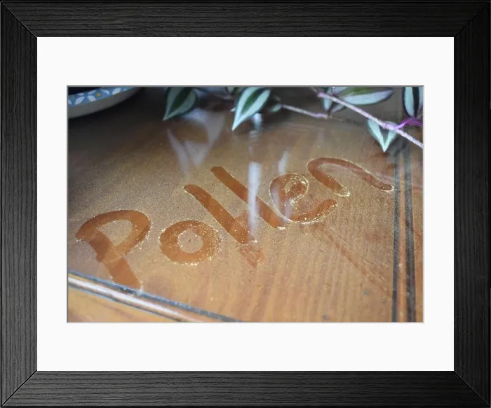 Framed Print : The word 'pollen' is written in pollen that has collected on a glass table top near an open window Framed Print : The word 'pollen' is written in pollen that has collected on a glass table top near an open window