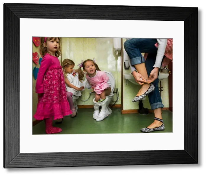 Framed Print : Little girls sitting on toilets Framed Print : Little girls sitting on toilets