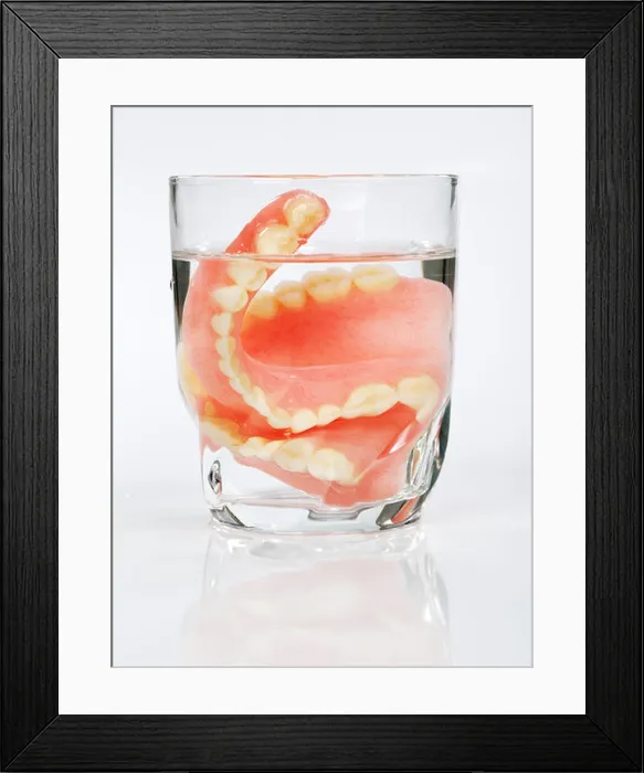 Framed Print : A set of dentures in a glass of water on a white background Framed Print : A set of dentures in a glass of water on a white background