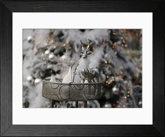 Framed Print : Christmas decoration in interior. A silver deer and a Christmas tree in a background
