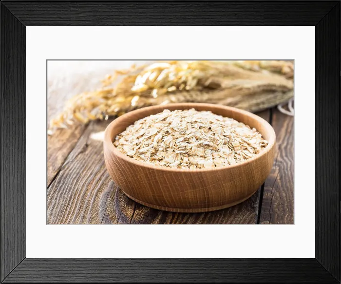 Framed Print : Rolled oat flakes in a wooden bowl and oat stalks Framed Print : Rolled oat flakes in a wooden bowl and oat stalks