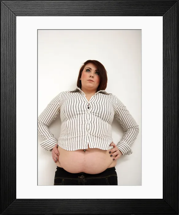 Framed Print : Large woman standing with hands on hips showing her fat belly Framed Print : Large woman standing with hands on hips showing her fat belly