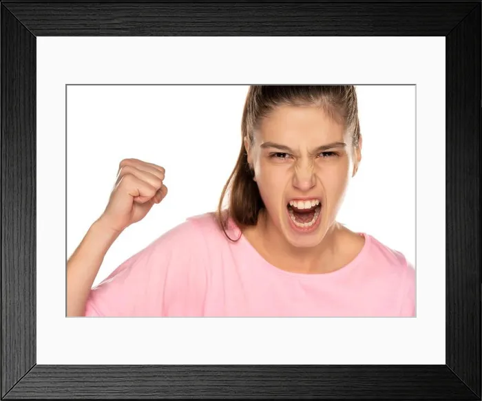 Framed Print : Portrait of young angry woman without makeup on white background