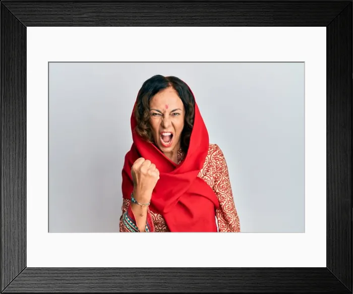 Framed Print : Middle age hispanic woman wearing tradition sherwani saree clothes angry and mad raising fist frustrated