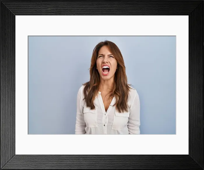 Framed Print : Hispanic woman standing over isolated background angry and mad screaming frustrated and furious Framed Print : Hispanic woman standing over isolated background angry and mad screaming frustrated and furious