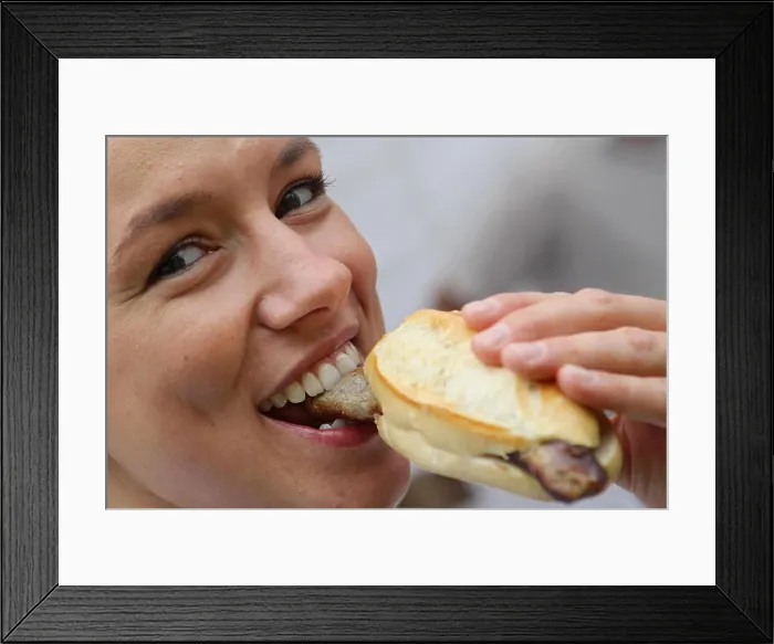 Framed Print : A woman eats bratwurst during the First Franconian Bratwurt summit meeting in Pegnitz Framed Print : A woman eats bratwurst during the First Franconian Bratwurt summit meeting in Pegnitz
