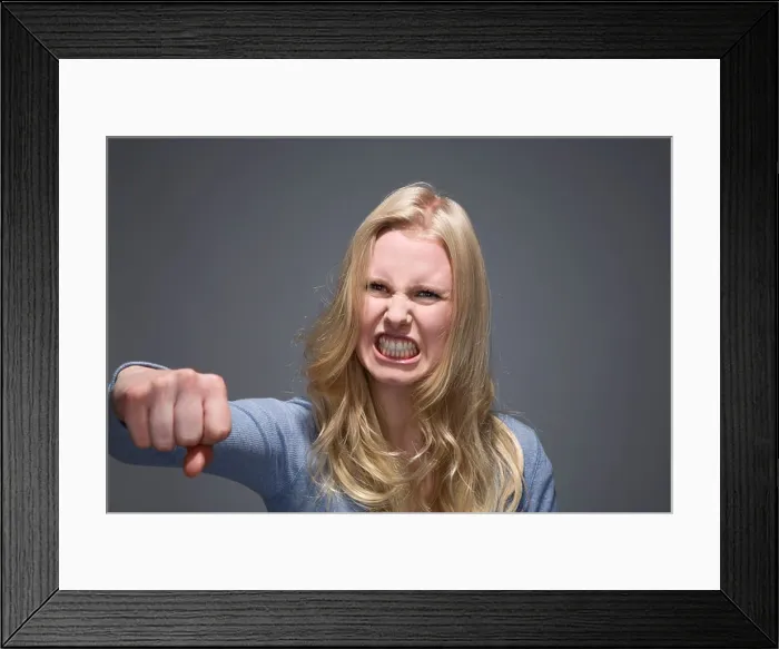 Framed Print : Portrait of furious young woman with outstretched fist and bared teeth Framed Print : Portrait of furious young woman with outstretched fist and bared teeth