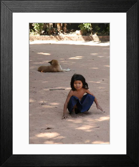 Framed Print : Photograph of a cute Cambodian girl and dog playing near a temple in Siem Reap Framed Print : Photograph of a cute Cambodian girl and dog playing near a temple in Siem Reap