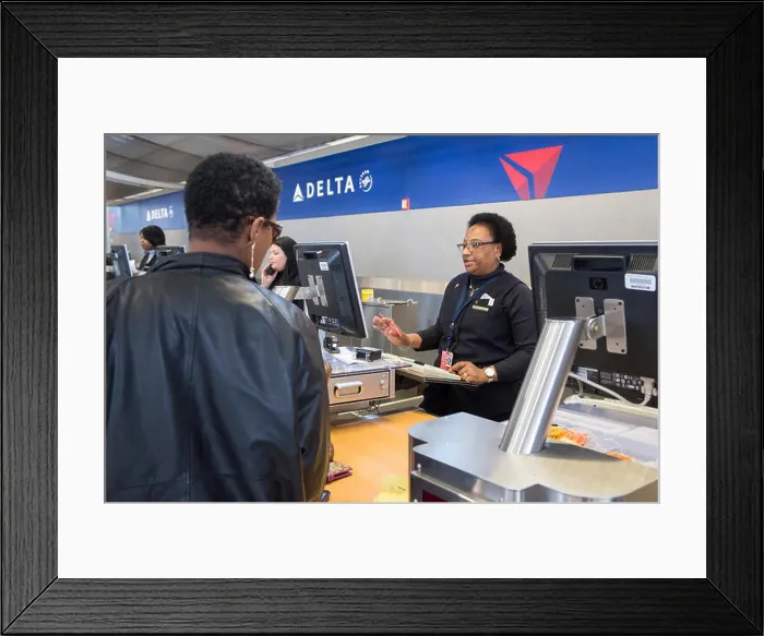 Framed Print : Romulus, Michigan - A Delta Air Lines ticket agent checks in a passenger at Detroit Metro Airport Framed Print : Romulus, Michigan - A Delta Air Lines ticket agent checks in a passenger at Detroit Metro Airport
