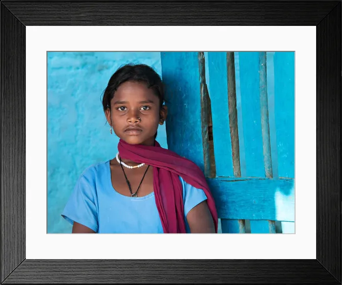 Framed Print : Beautiful indian girl portrait wearing blue top against a blue wall in Kanha village near the Kanha National Park Framed Print : Beautiful indian girl portrait wearing blue top against a blue wall in Kanha village near the Kanha National Park