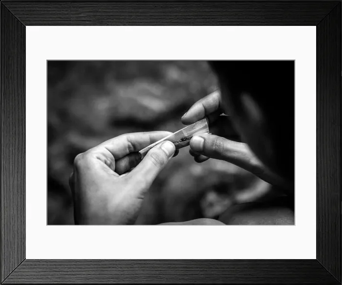 Framed Print : Rolling a cigarette by hand, concept of smoking, drugs and addiction, heavy grain black and white photo Framed Print : Rolling a cigarette by hand, concept of smoking, drugs and addiction, heavy grain black and white photo