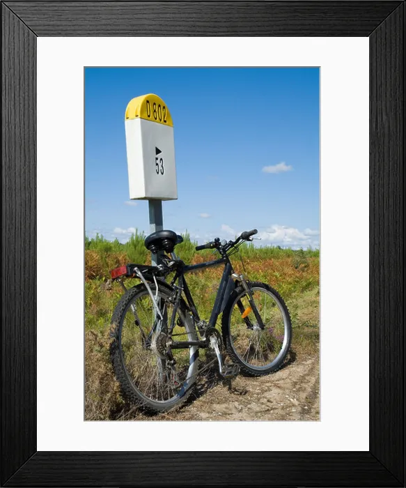 Framed Print : Mountain bike parked against a French milestone D802 country road in Landes Forest, France