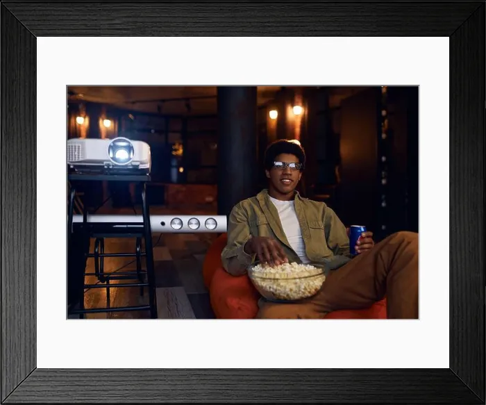 Framed Print : Man enjoy watching film using video projector Framed Print : Man enjoy watching film using video projector