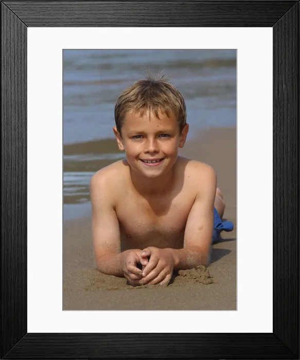 Framed Print : Young boy white caucasian aged 10 years old lying on sand beach sea shoreline Framed Print : Young boy white caucasian aged 10 years old lying on sand beach sea shoreline
