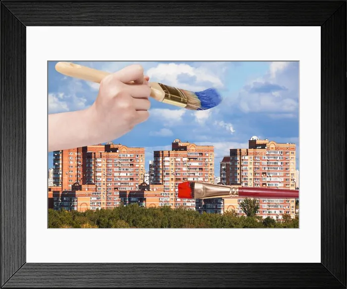 Framed Print : nature concept - hand with paintbrush paints blue clouds over modern urban buildings Framed Print : nature concept - hand with paintbrush paints blue clouds over modern urban buildings