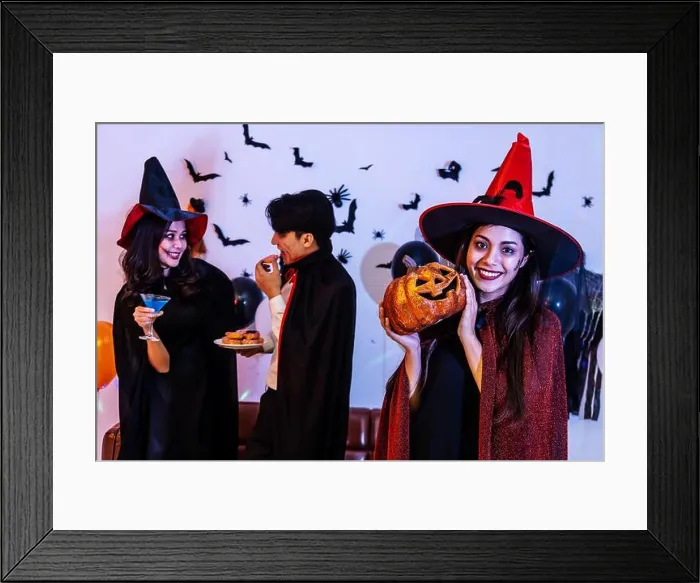 Framed Print : Young Asian woman in costume celebrating Halloween holding a carved pumpkin