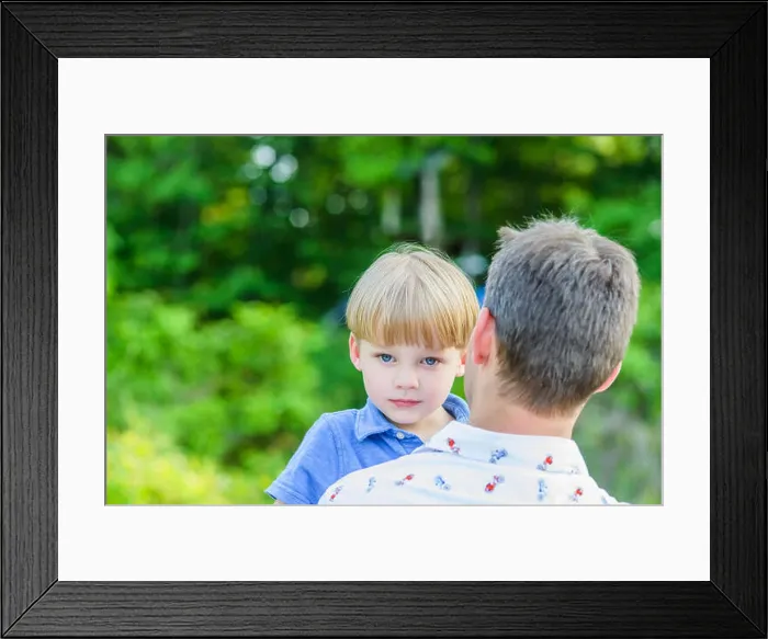 Framed Print : Boy looking at camera over fathers shoulders Framed Print : Boy looking at camera over fathers shoulders