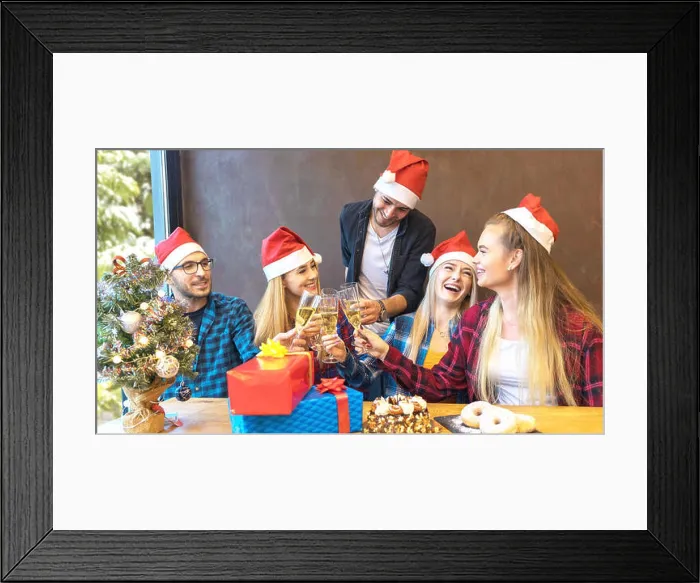 Framed Print : Happy young friends with santa hats celebrating Christmas toasting champagne at party Framed Print : Happy young friends with santa hats celebrating Christmas toasting champagne at party