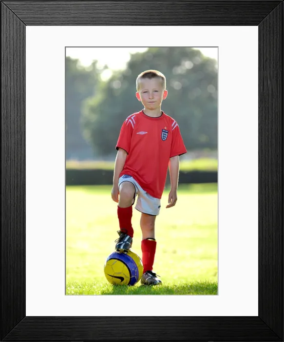 Framed Print : Young Boy Standing with Football Framed Print : Young Boy Standing with Football