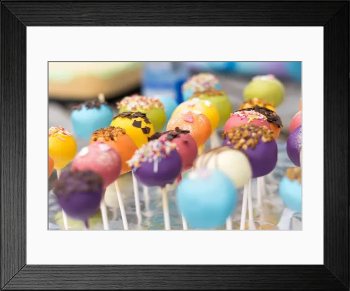 Framed Print : A vibrant array of colorful cake pops decorated with sprinkles and chocolate pieces, displayed on a festive table Framed Print : A vibrant array of colorful cake pops decorated with sprinkles and chocolate pieces, displayed on a festive table