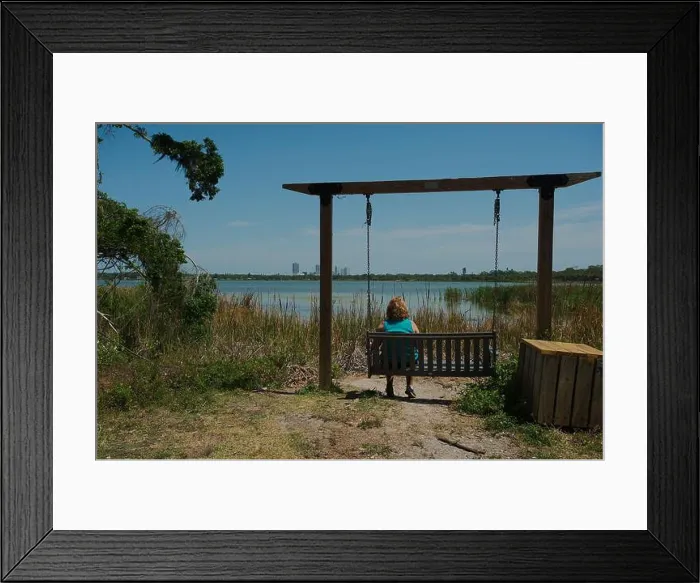 Framed Print : Woman Relaxing on a Empty Lakeside Swing Amid Scenic Natural Surroundings Framed Print : Woman Relaxing on a Empty Lakeside Swing Amid Scenic Natural Surroundings
