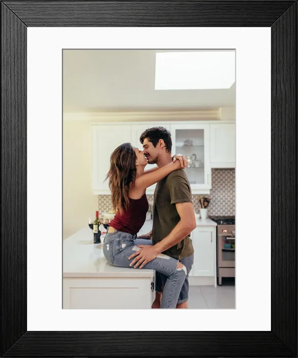Framed Print : Affectionate young couple together in the kitchen at home. Couple in love kissing at home Framed Print : Affectionate young couple together in the kitchen at home. Couple in love kissing at home
