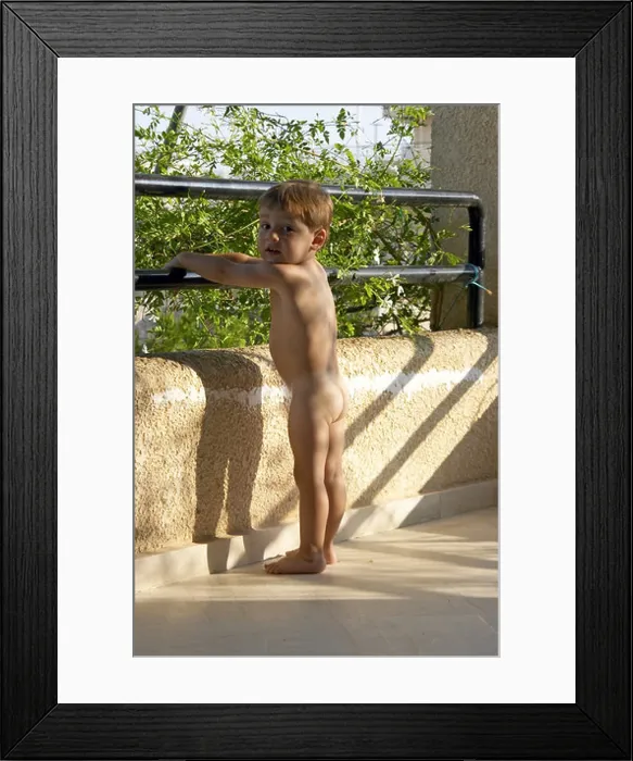 Framed Print : Young boy naked nude or bare standing on a balcony Framed Print : Young boy naked nude or bare standing on a balcony