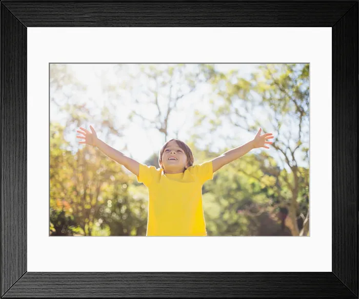 Framed Print : Boy standing with arms outstretched in park Framed Print : Boy standing with arms outstretched in park