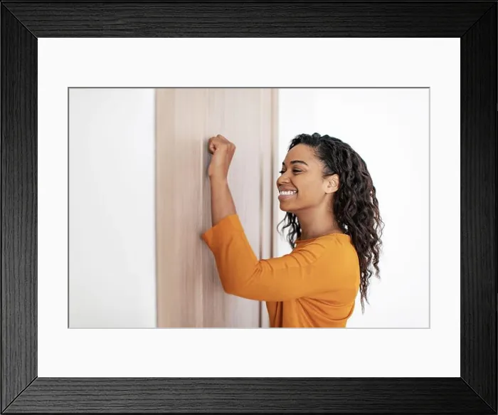 Framed Print : Happy African American Female Knocking At Door Indoors, Side View