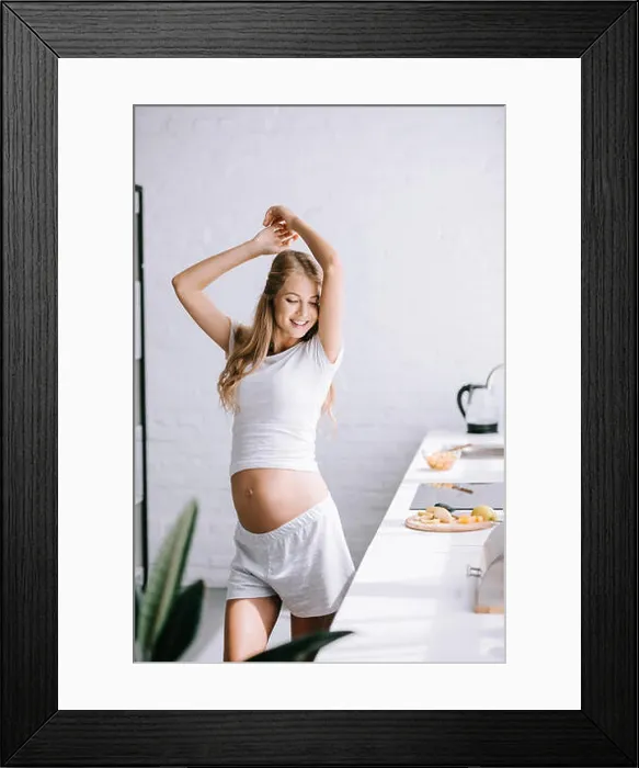 Framed Print : smiling beautiful pregnant woman in white clothing standing in kitchen at home Framed Print : smiling beautiful pregnant woman in white clothing standing in kitchen at home