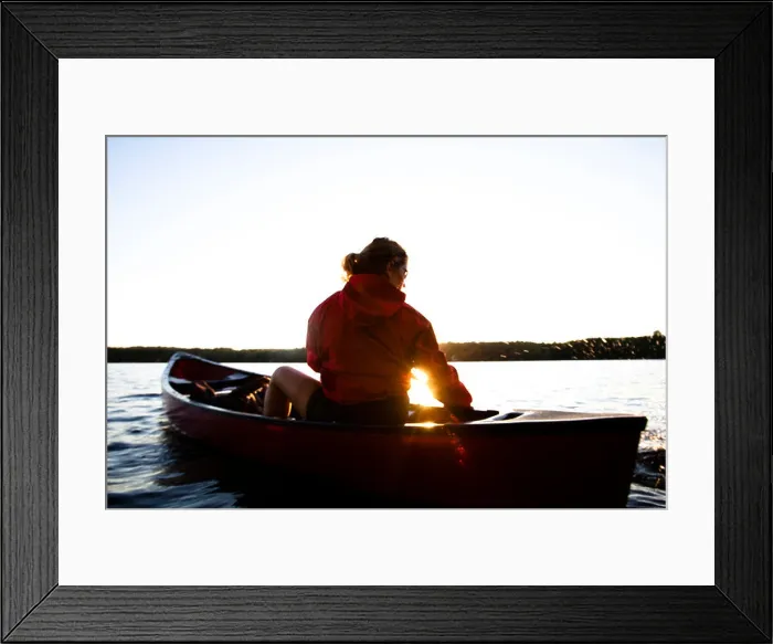 Framed Print : A woman canoes on Cobbosseecontee Lake, in southern Maine