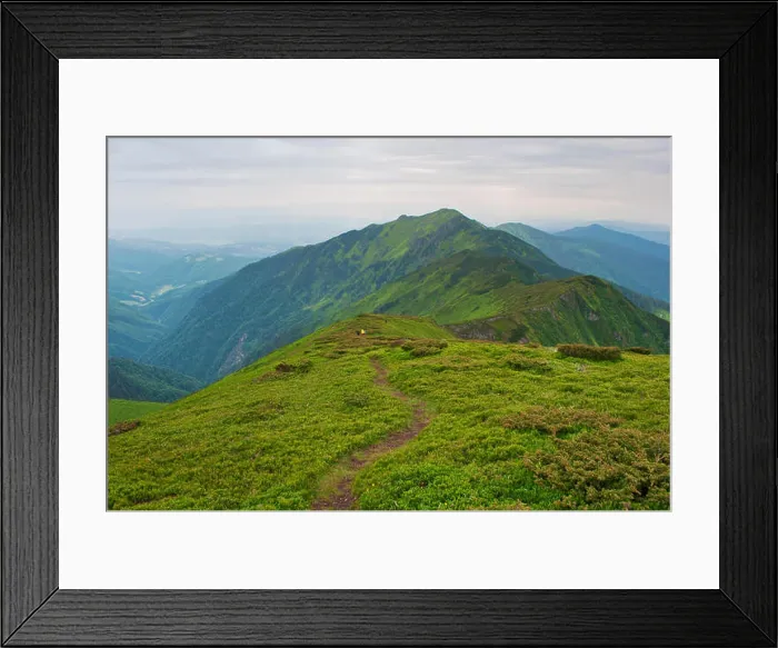 Framed Print : Small figures of travelers descending down a winding path leading to majestic mountain peak Framed Print : Small figures of travelers descending down a winding path leading to majestic mountain peak