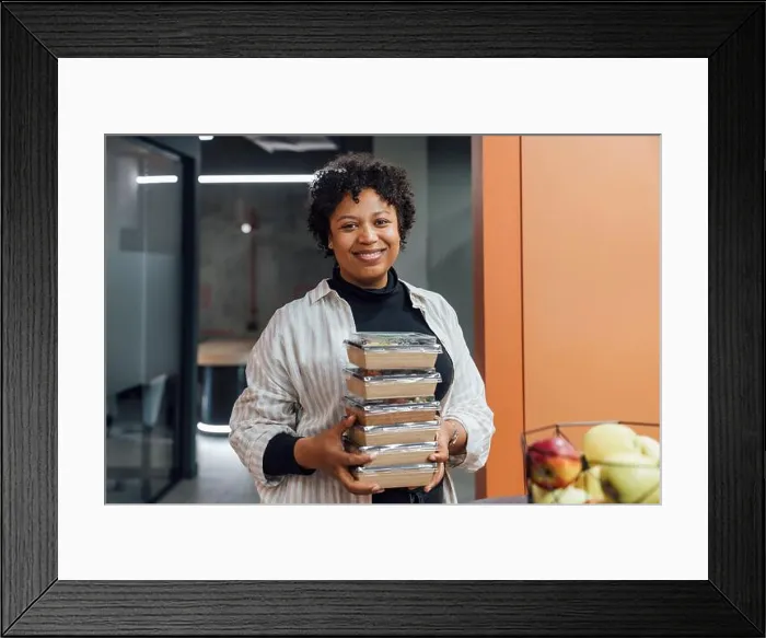 Framed Print : Happy young woman with take away food boxes standing in office