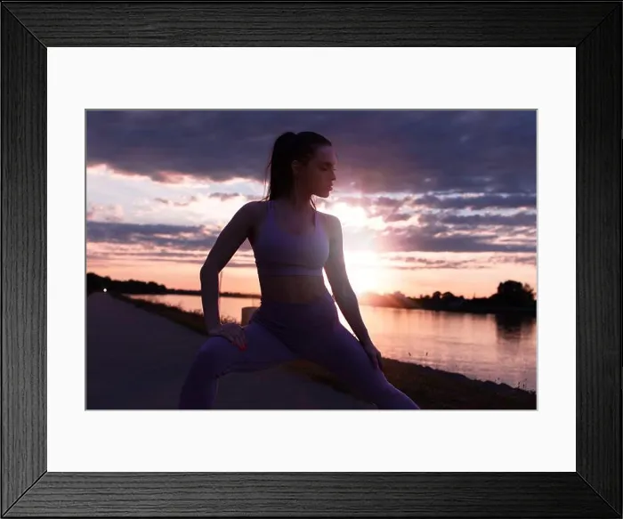 Framed Print : Young woman in sportswear stretching before running at sunrise, warm up exercise Framed Print : Young woman in sportswear stretching before running at sunrise, warm up exercise