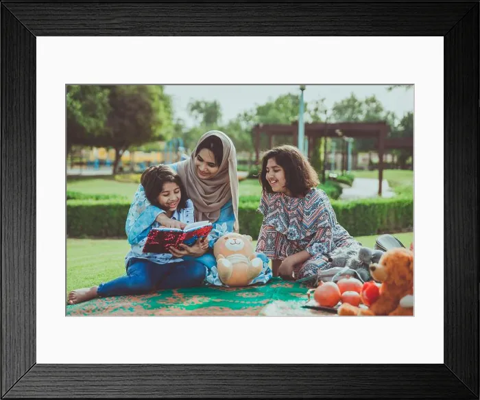 Framed Print : Warm lifestyle image of a mother with her two daughters enjoying time together at a Dubai park