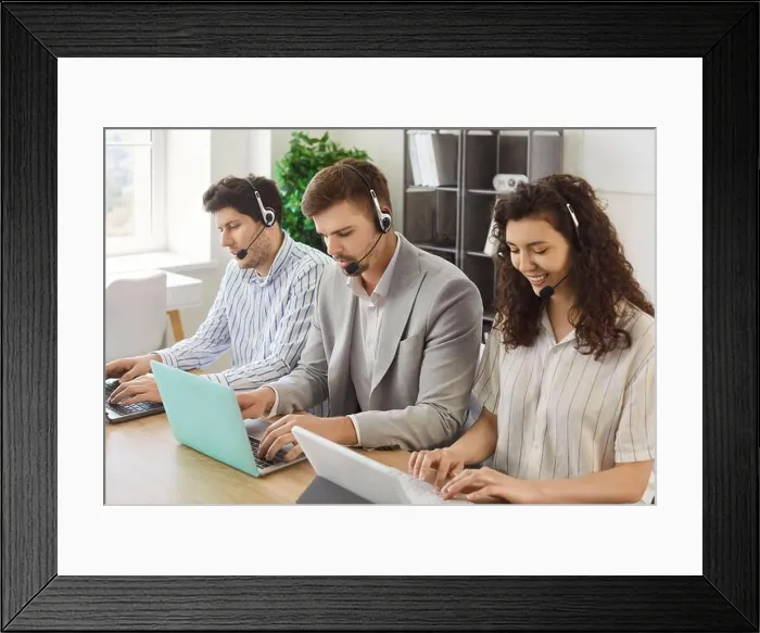 Framed Print : Young business people sitting in a row working in call center at online support service office Framed Print : Young business people sitting in a row working in call center at online support service office