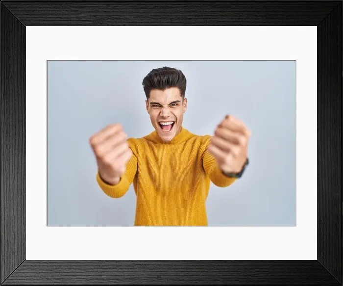 Framed Print : Young hispanic man standing over blue background angry and mad raising fists frustrated Framed Print : Young hispanic man standing over blue background angry and mad raising fists frustrated