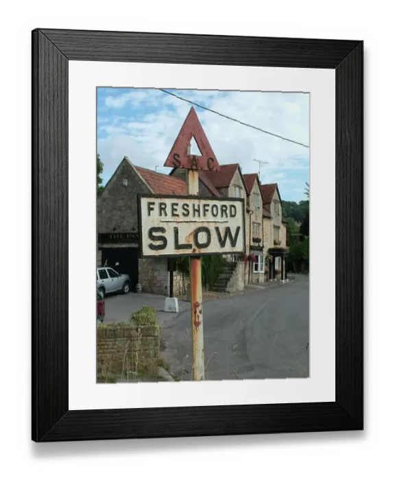 Framed Print : Ancient road sign close to the inn at Freshford , a village in the North of Somerset advising the traffic to slow down.