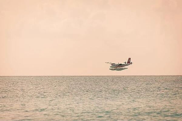 05.06.2019 - Ari Atoll, Maldives: Exotic scene with seaplane on Maldives sea landing. Vacation holiday in Maldives concept background. Seaplane taxi
